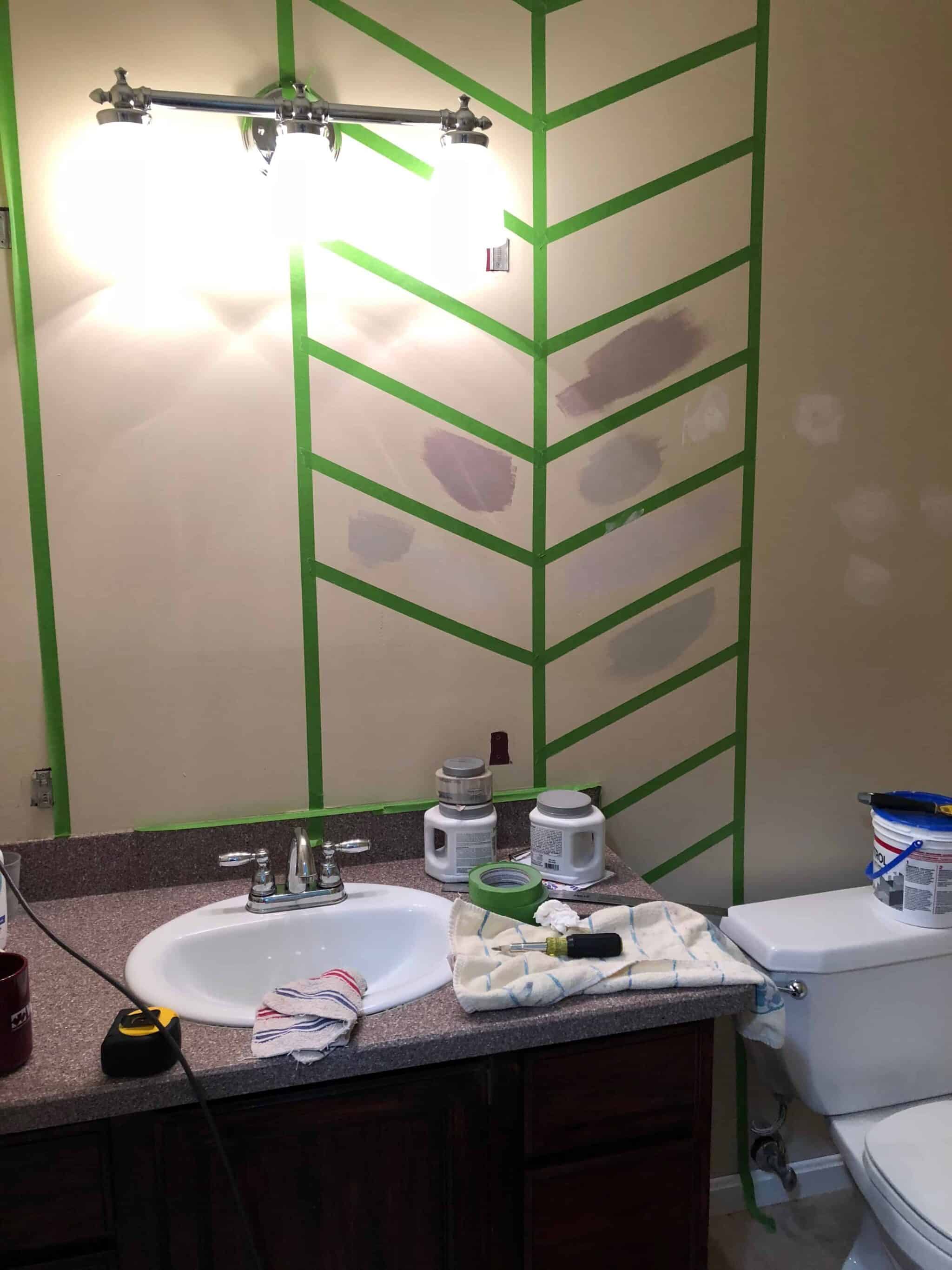 Herringbone taped wall with green tape and testing gray paints