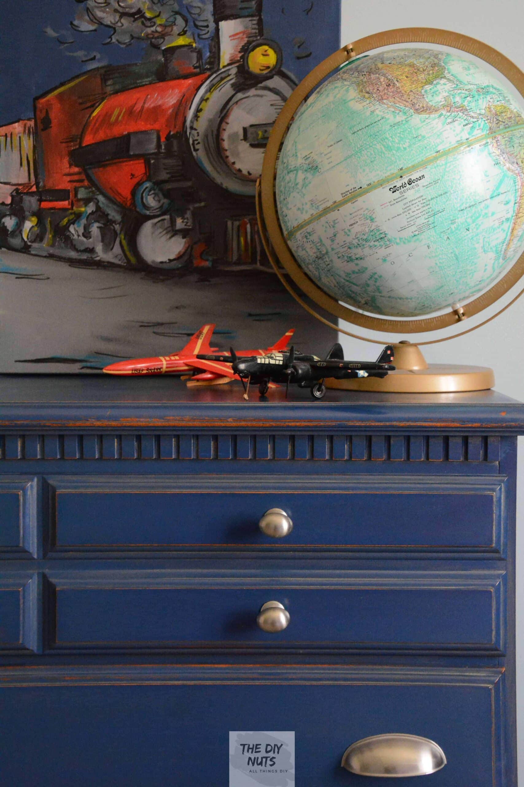 Blue Dresser with globe, small model planes and train artwork