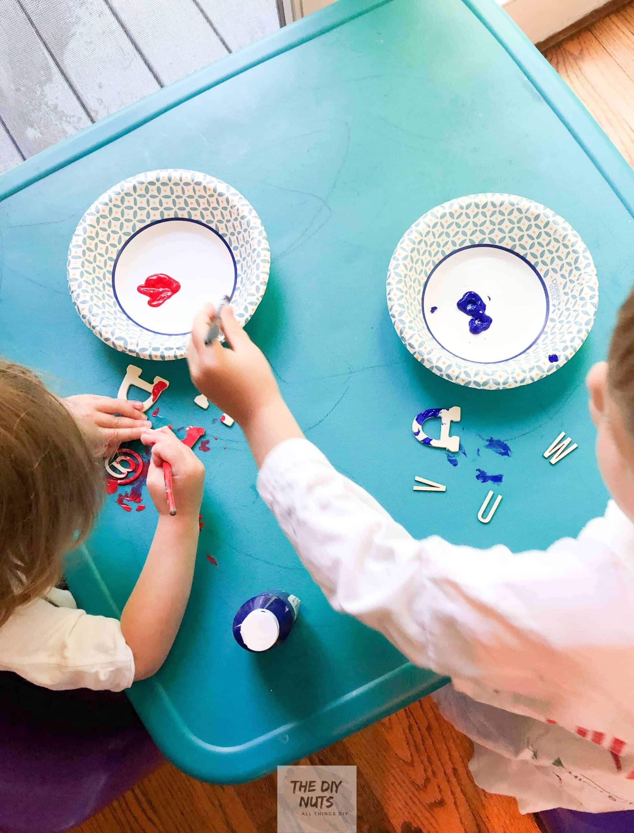 Children painting wooden letters for DIY word art canvas project
