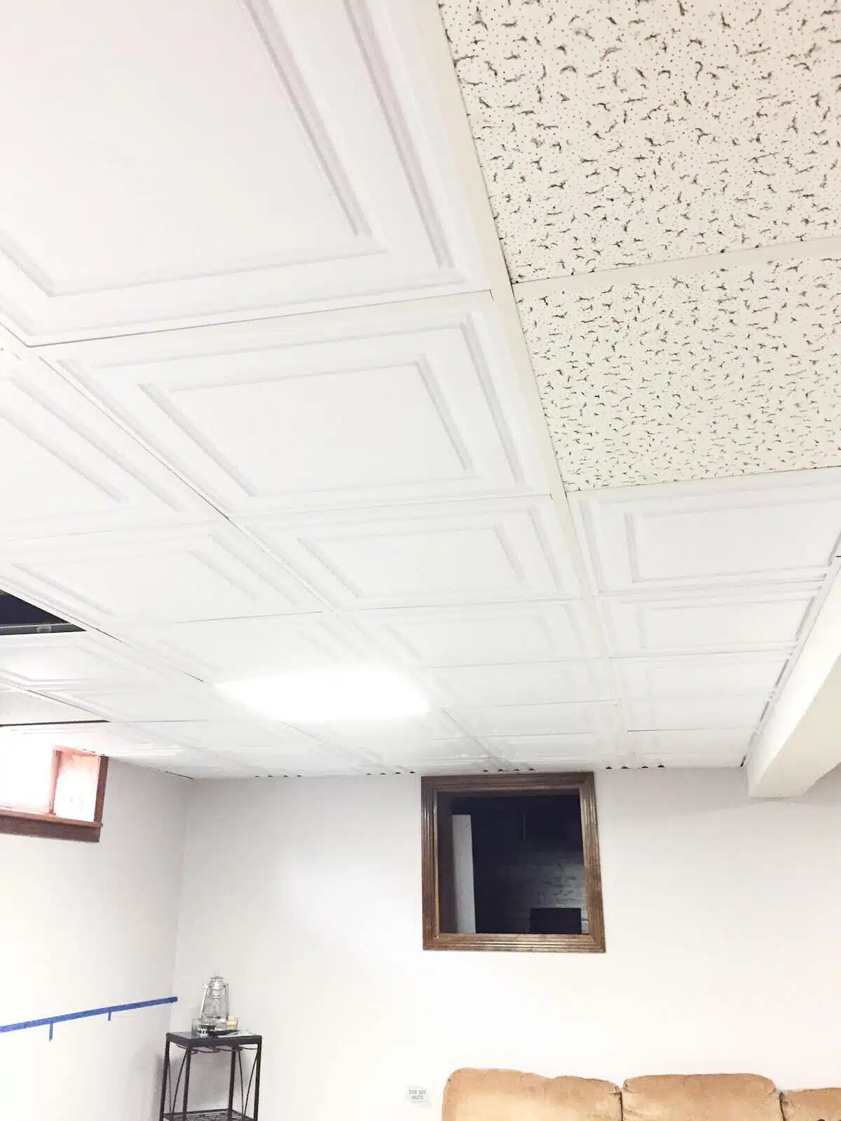 new drop ceiling tiles on part of ceiling with old ones in two spots in basement.
