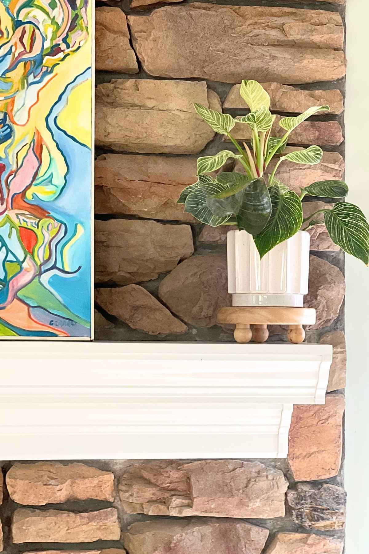 painted white mantel with plant and painting on it.