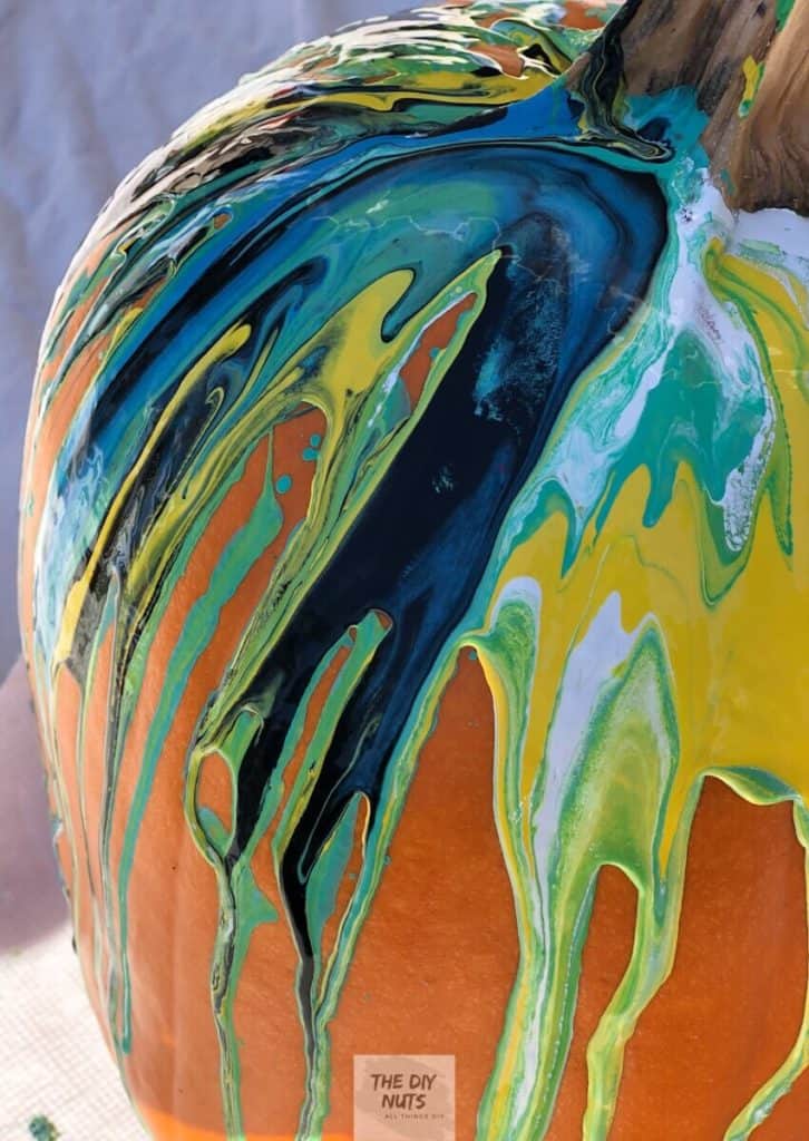 Paint pour pumpkin with blue, teal, yellow, white and black marble effect