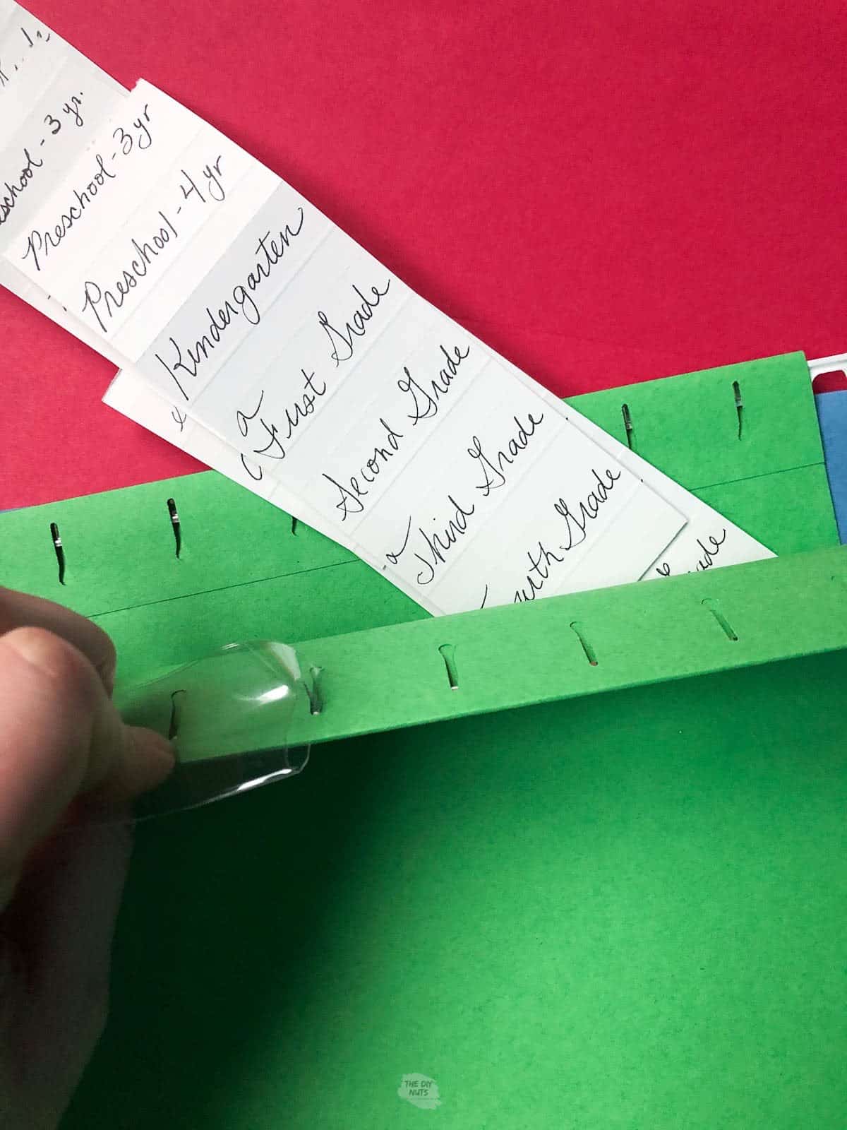 labels with grades written on in green file folder.