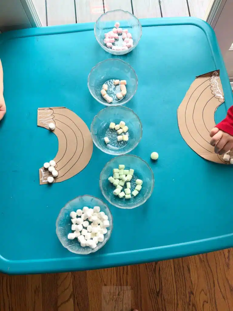 Toddlers gluing on marshmellows to rainbow craft