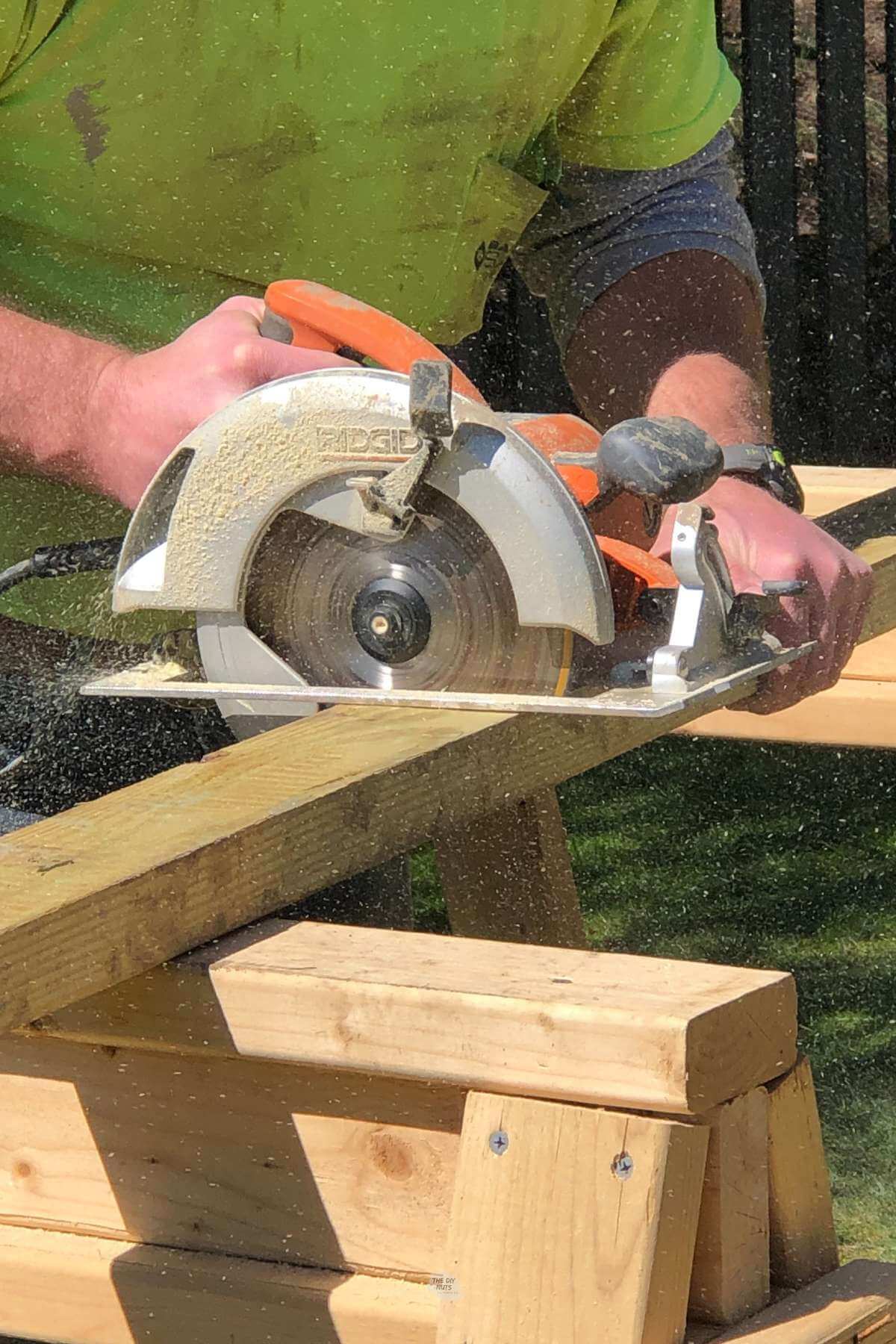 man using circular saw to cut 2x4.