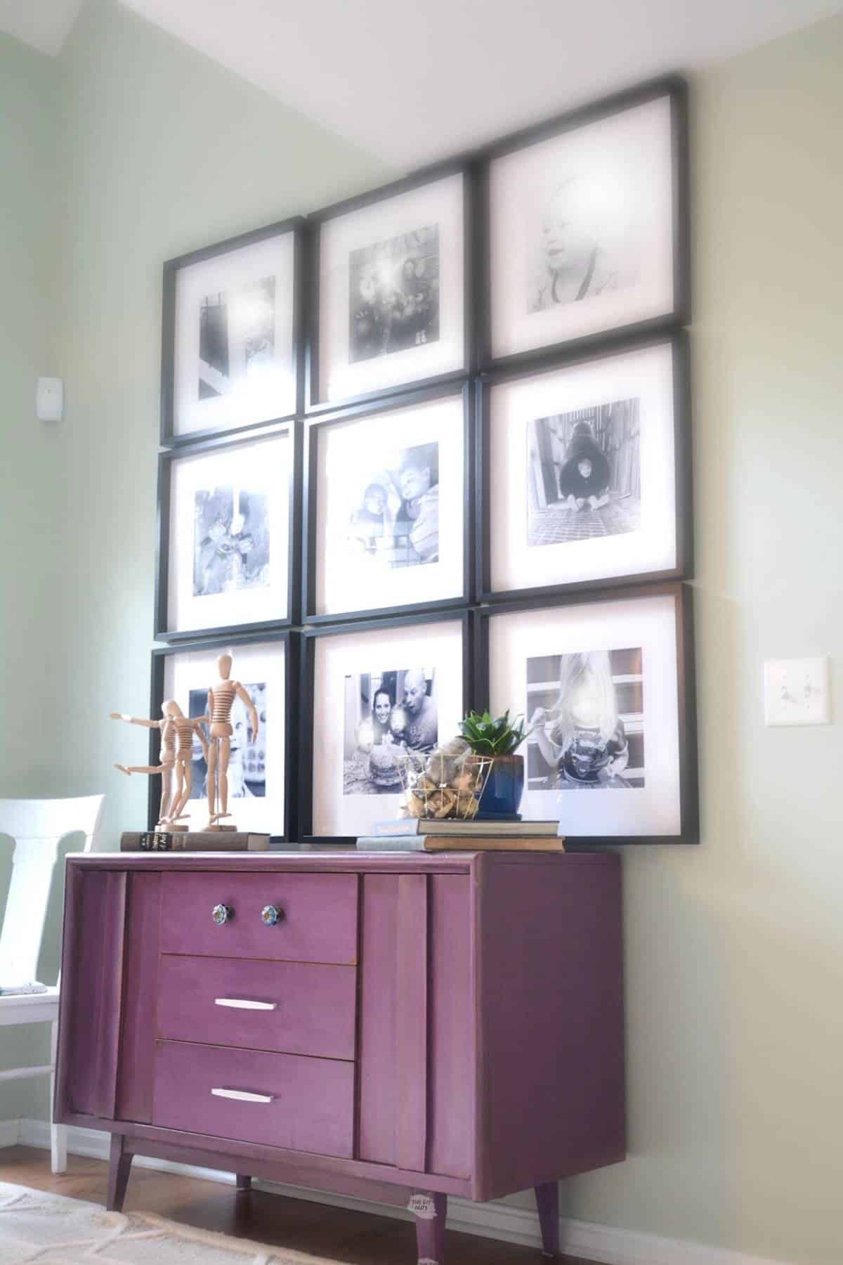 9 black frames on wall above purple dresser.