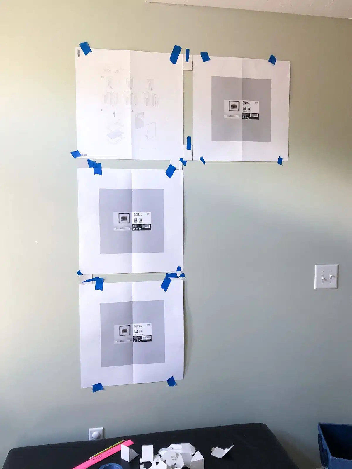 4 paper squares tape to wall.