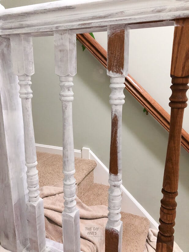 Oak banister and railing being primed with white primer on some areas.