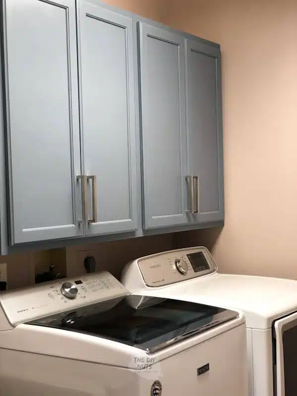 Large Gray-blue laundry room cabinets above washer and dryer