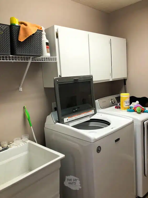 Before Laundry Room makeover with old cabinets and wire shelving