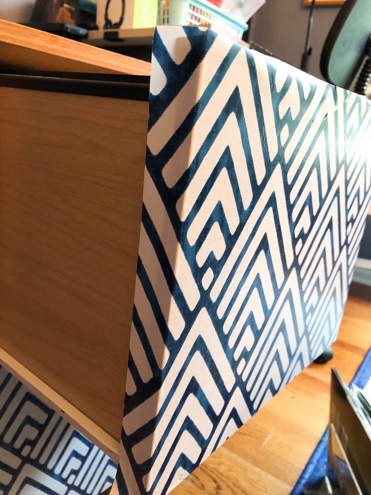side view of drawer of file cabinet covered in blue and white contact paper.