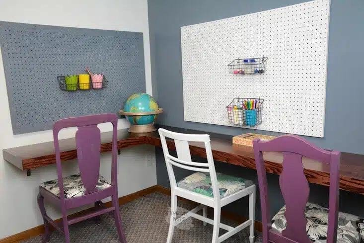 Floating corner desk with pegboards and repurposed chairs