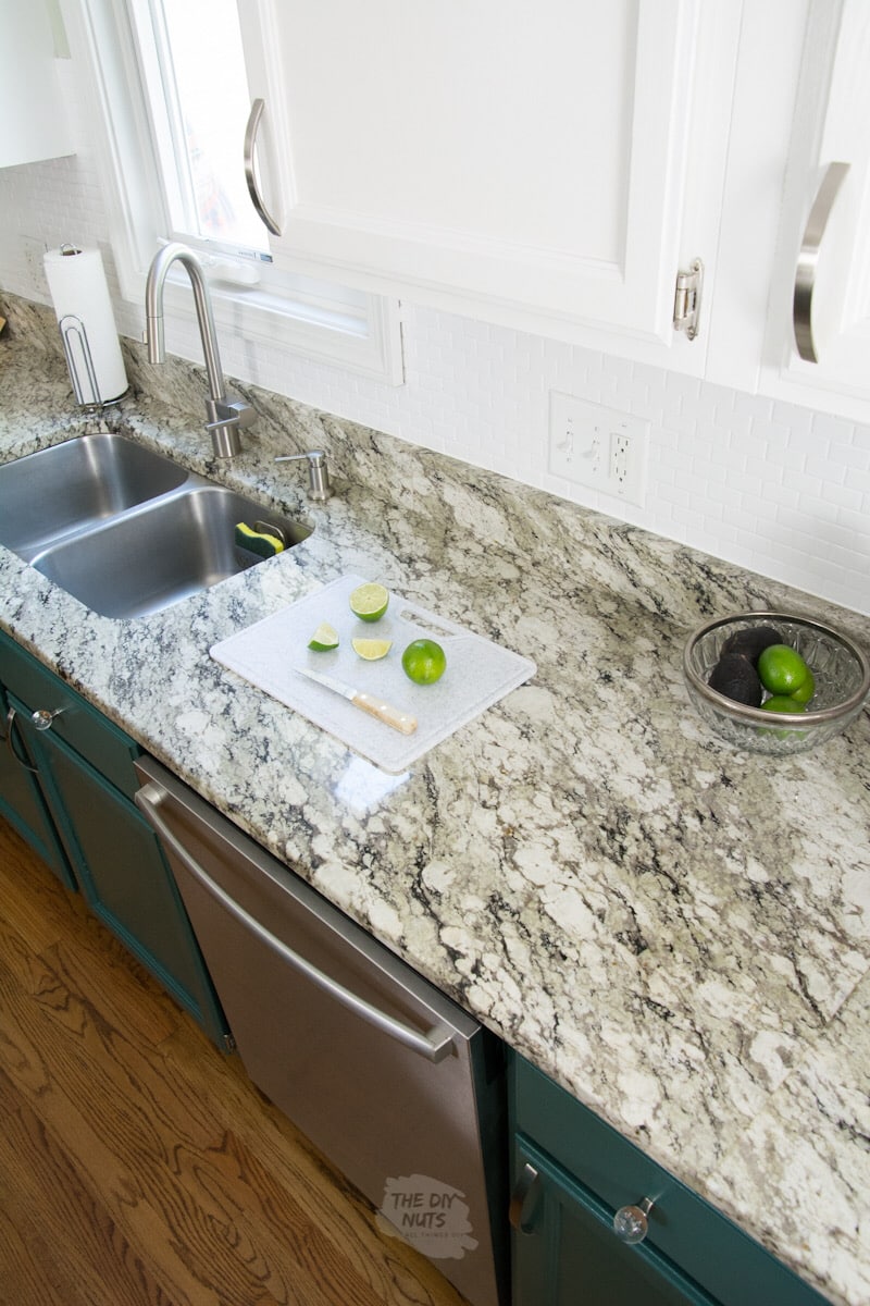repainted kitchen cabinets and granite countertops and limes on a cutting board