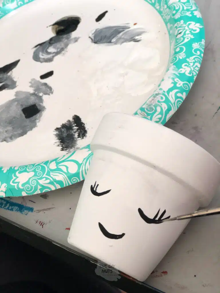 painted simple black line face on terracotta pot