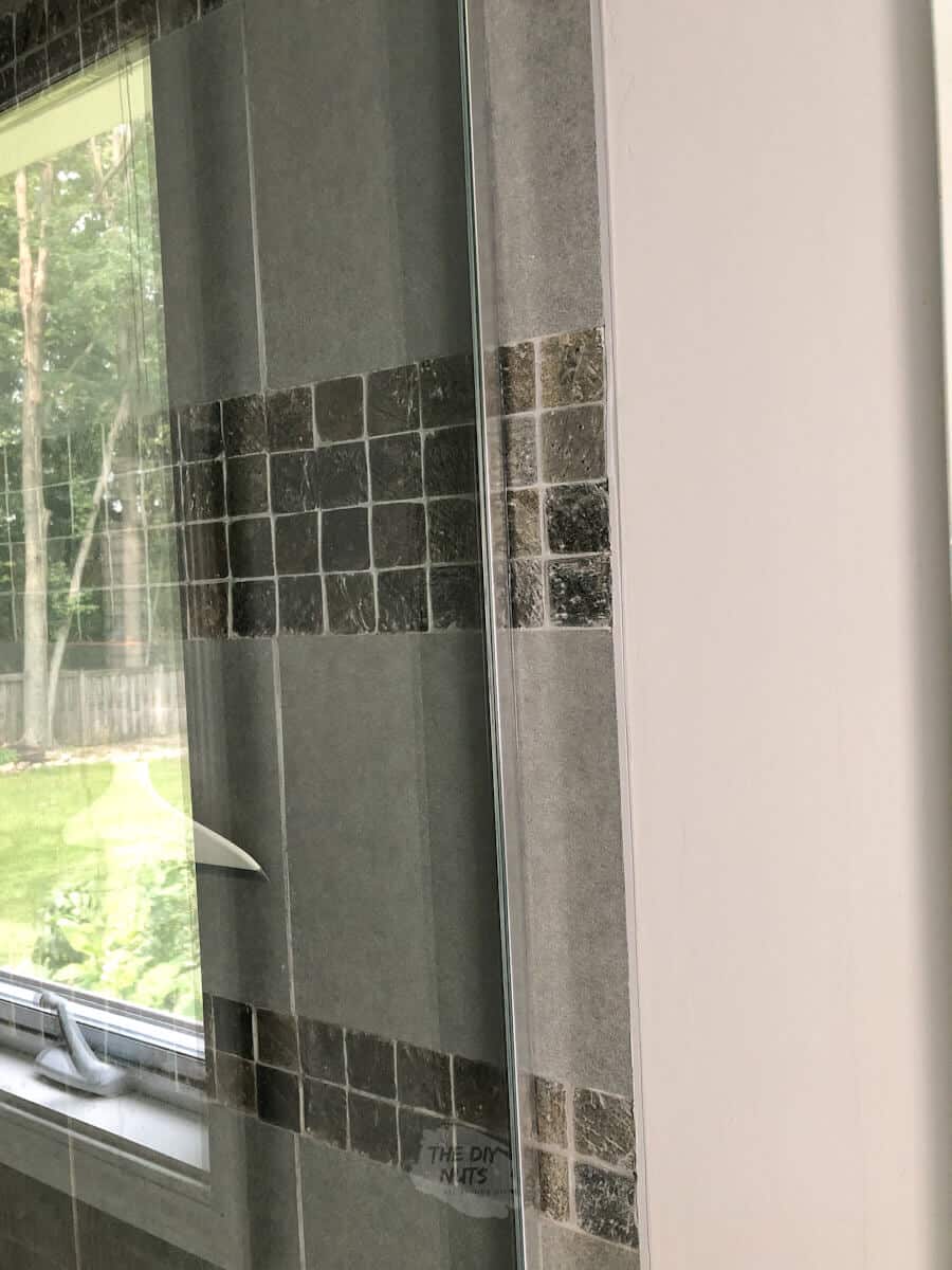 slate and gray tile next to grayish paint color with glass door for shower.