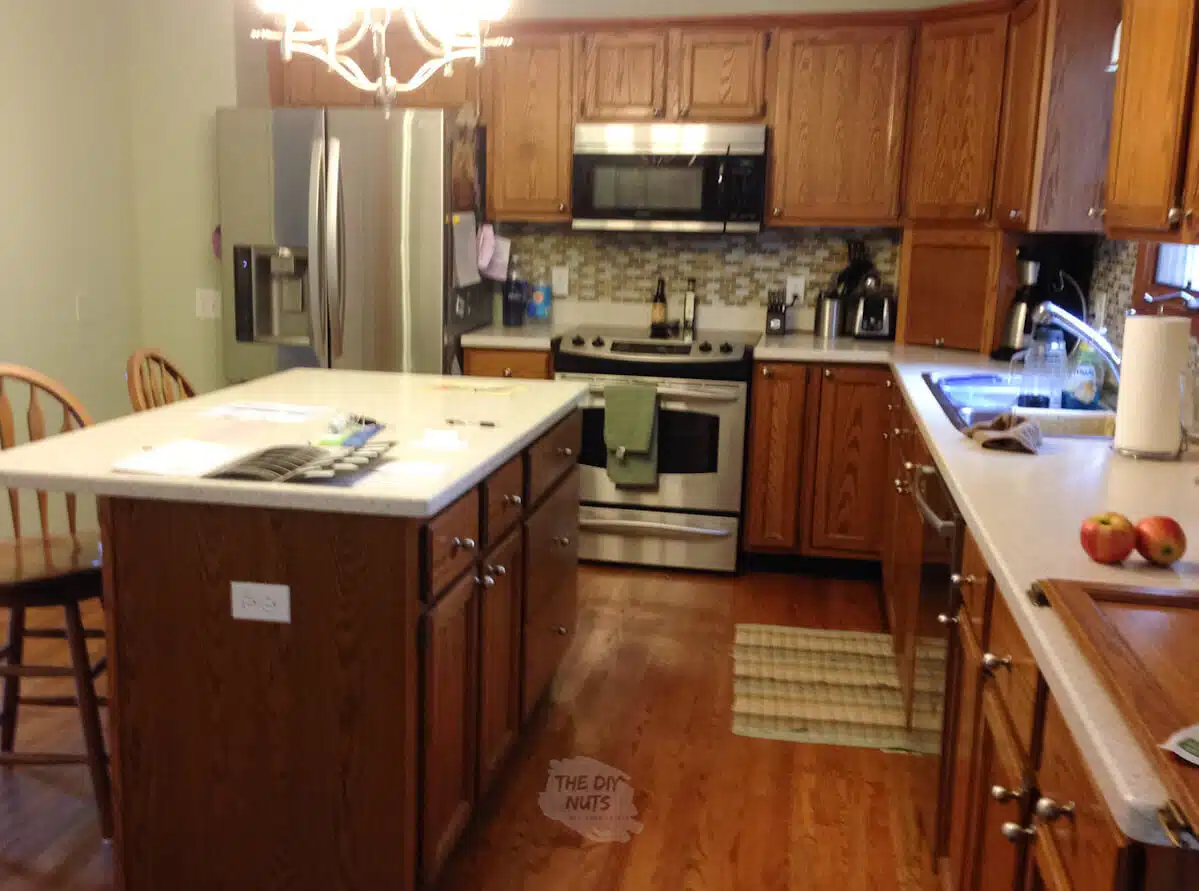 before kitchen makeover oak cabinets with laminate countertops and stainless steel appliances.