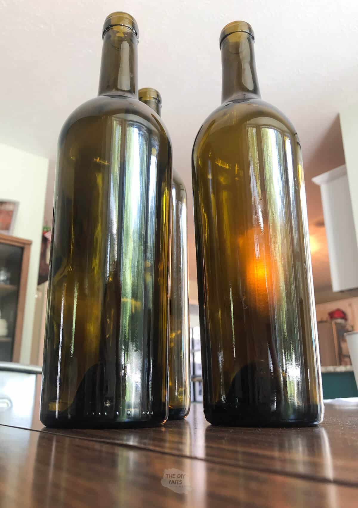 3 wine bottles without labels on table.