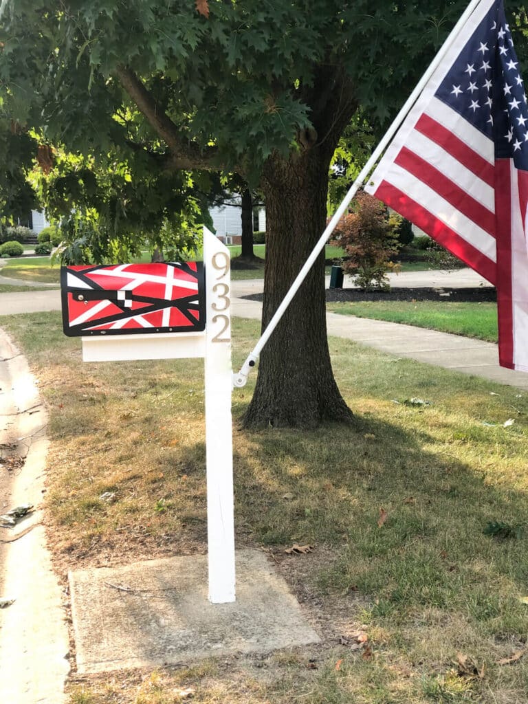 red frankenstrat painted design on mailbox with white post and American flag