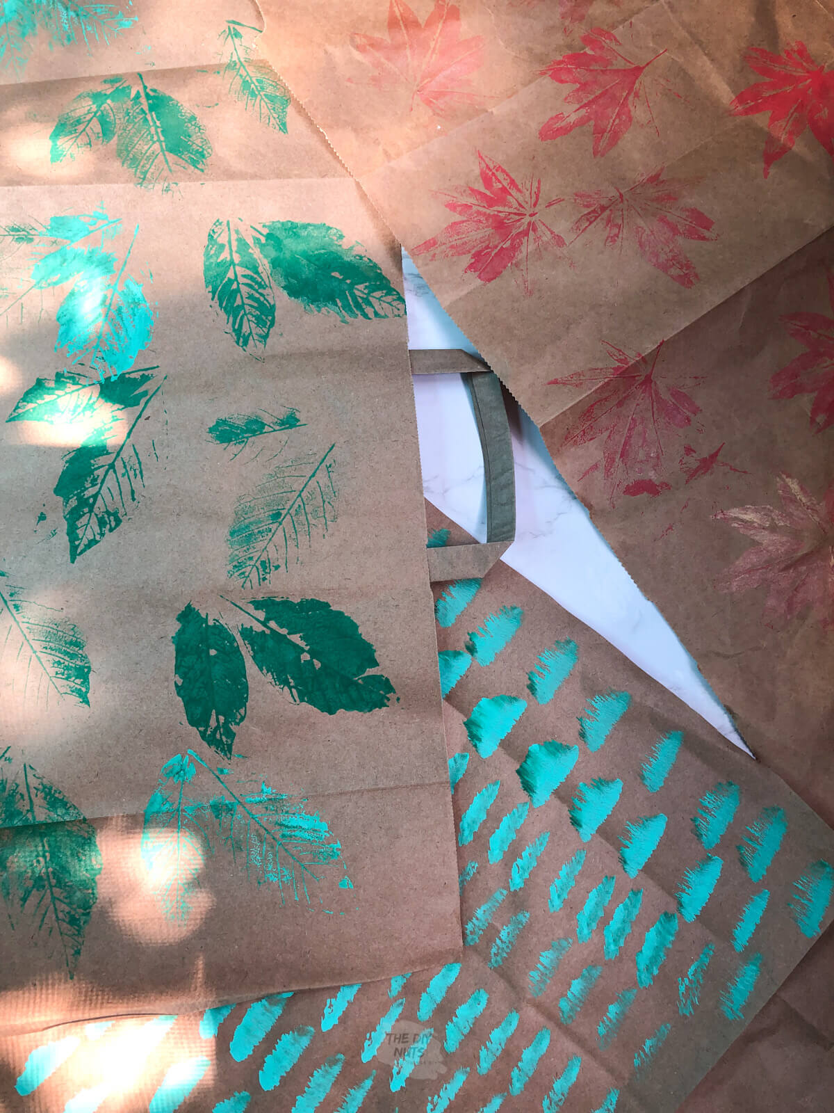 brown bags with handpainted and printed leaves to make cheap homemade wrapping paper