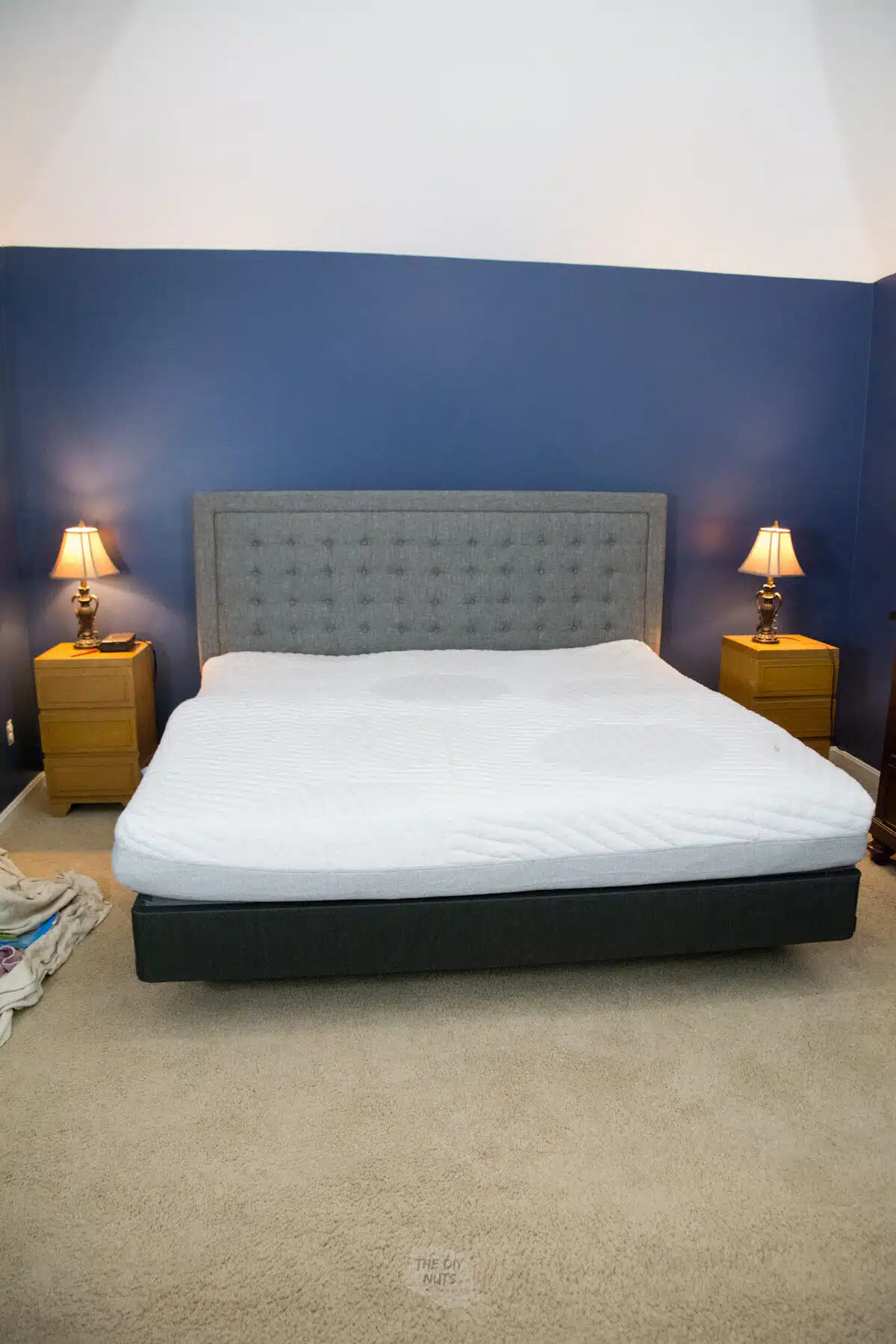 Casper Wave hybrid mattress on foundation with gray headboard in navy blue bedroom