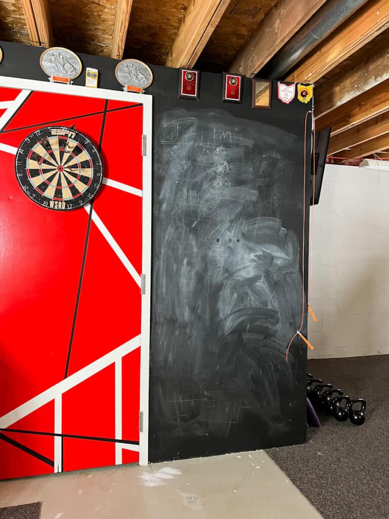 before chalkboard mural in basement with red Frankenstrat door design and dartboard