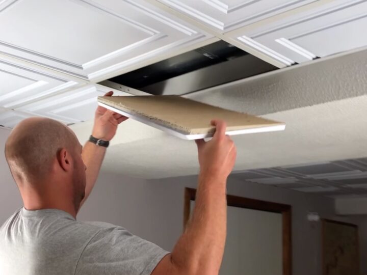 man putting in new drop ceiling tiles