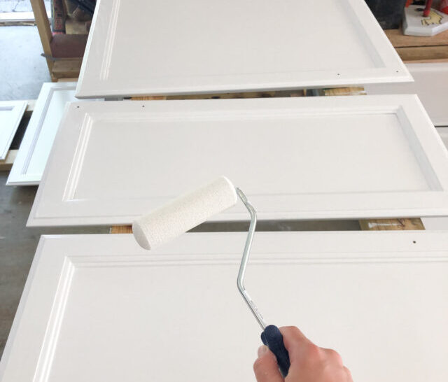 white paint roller painting cabinet doors