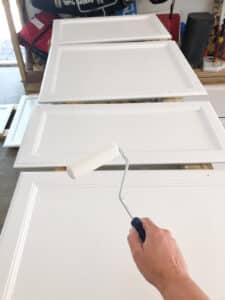 white paint roller painting cabinet doors