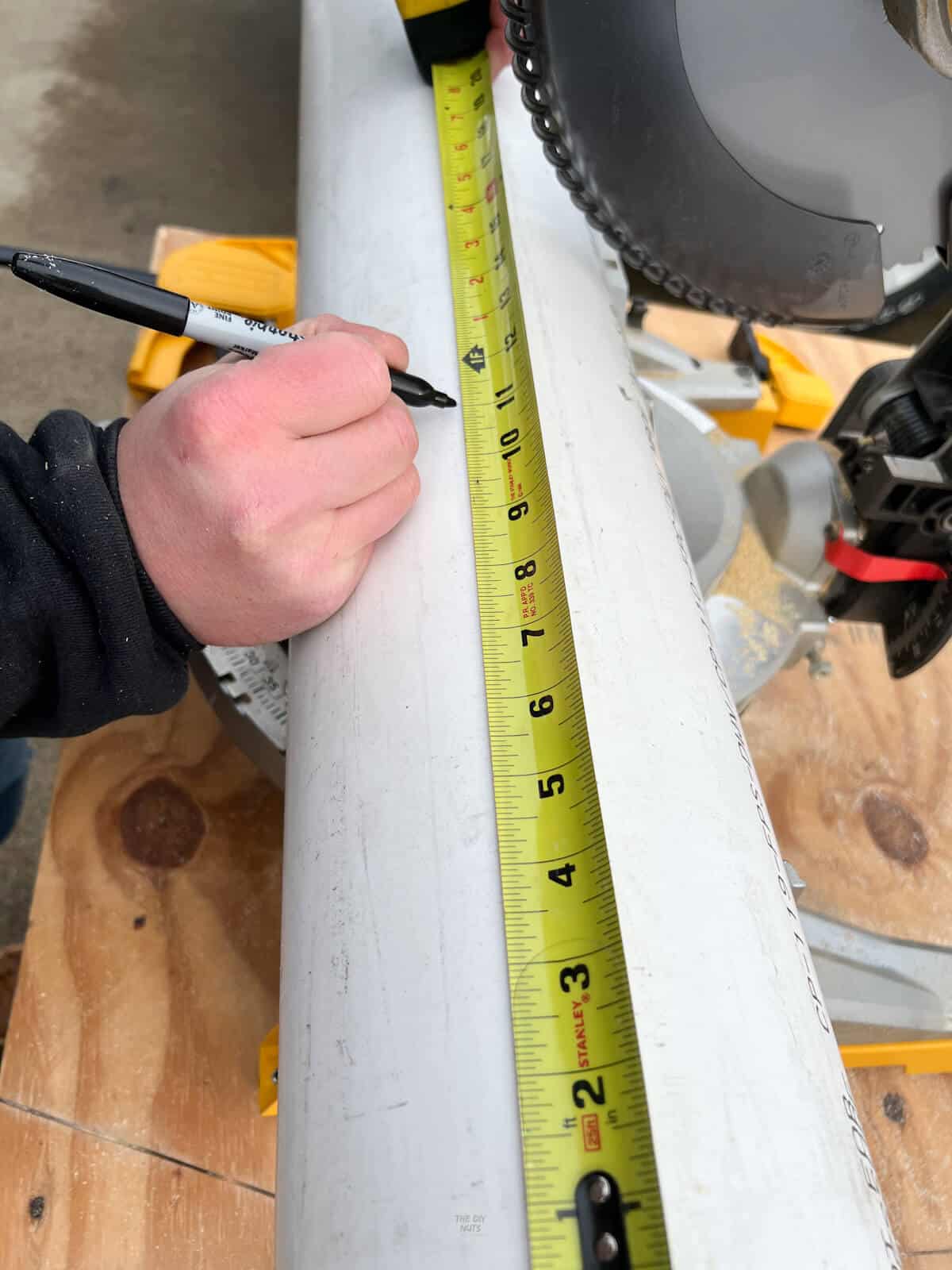 Use a tape measurer and sharpie marker to mark length on PVC pipe.