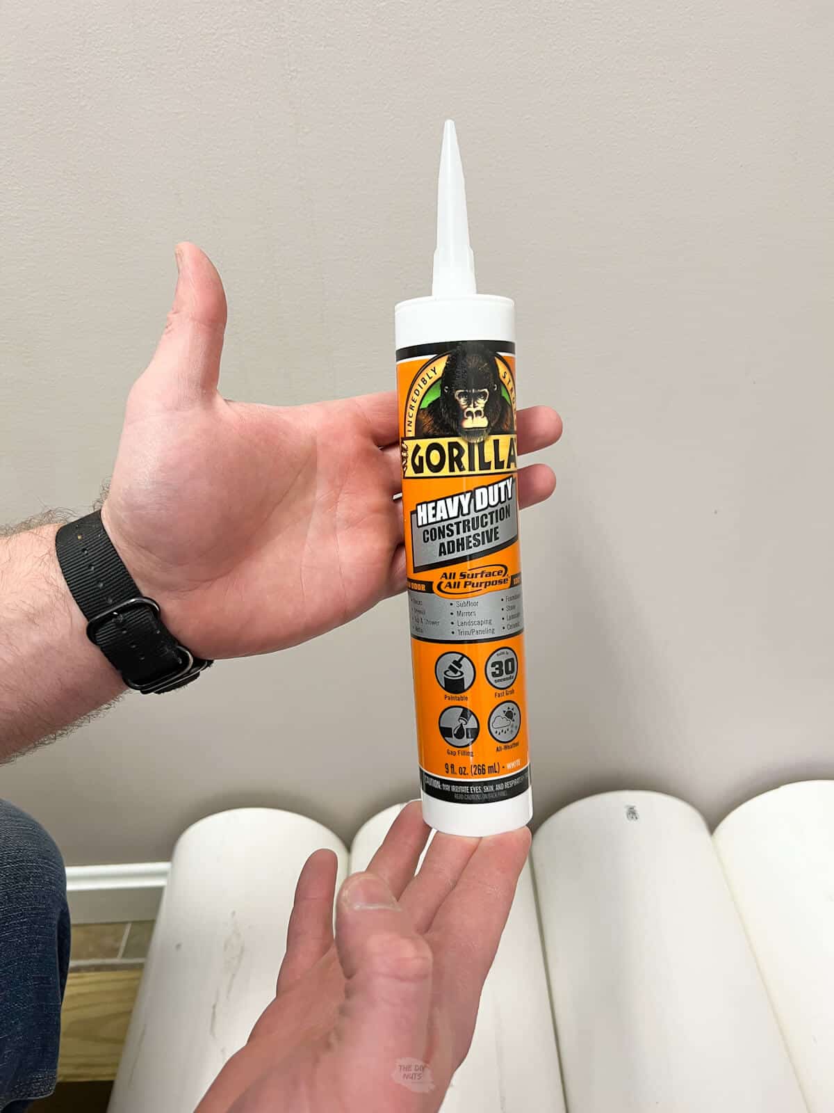 hands holding max strength Gorilla Glue used on PVC shoe rack.