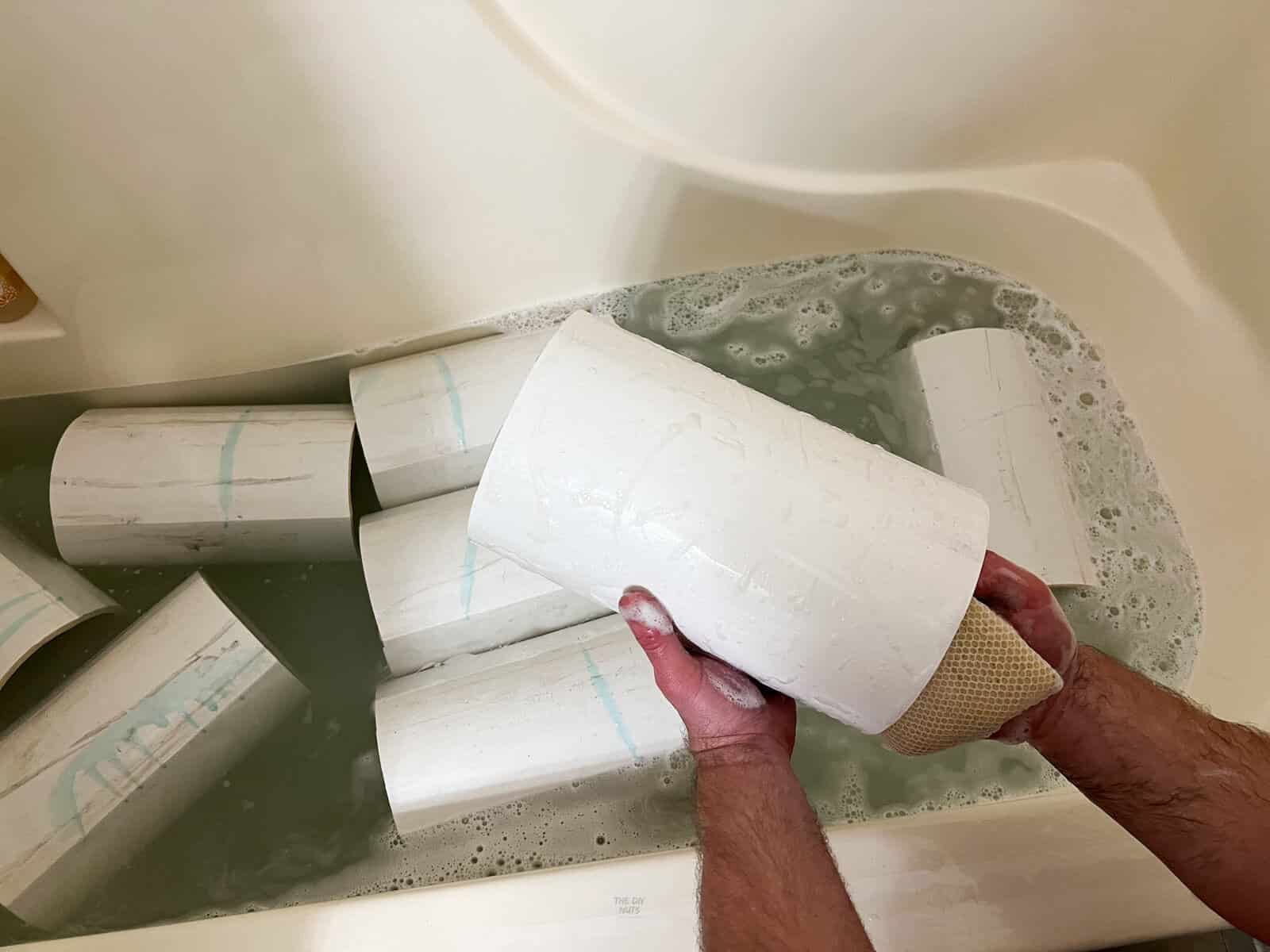 PVC pieces being cleaned in a bathroom tub.