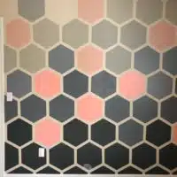 hexagon painted accent wall with gray and pink painted designs.