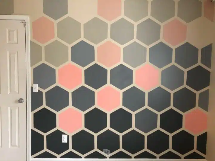 hexagon painted accent wall with gray and pink painted designs.