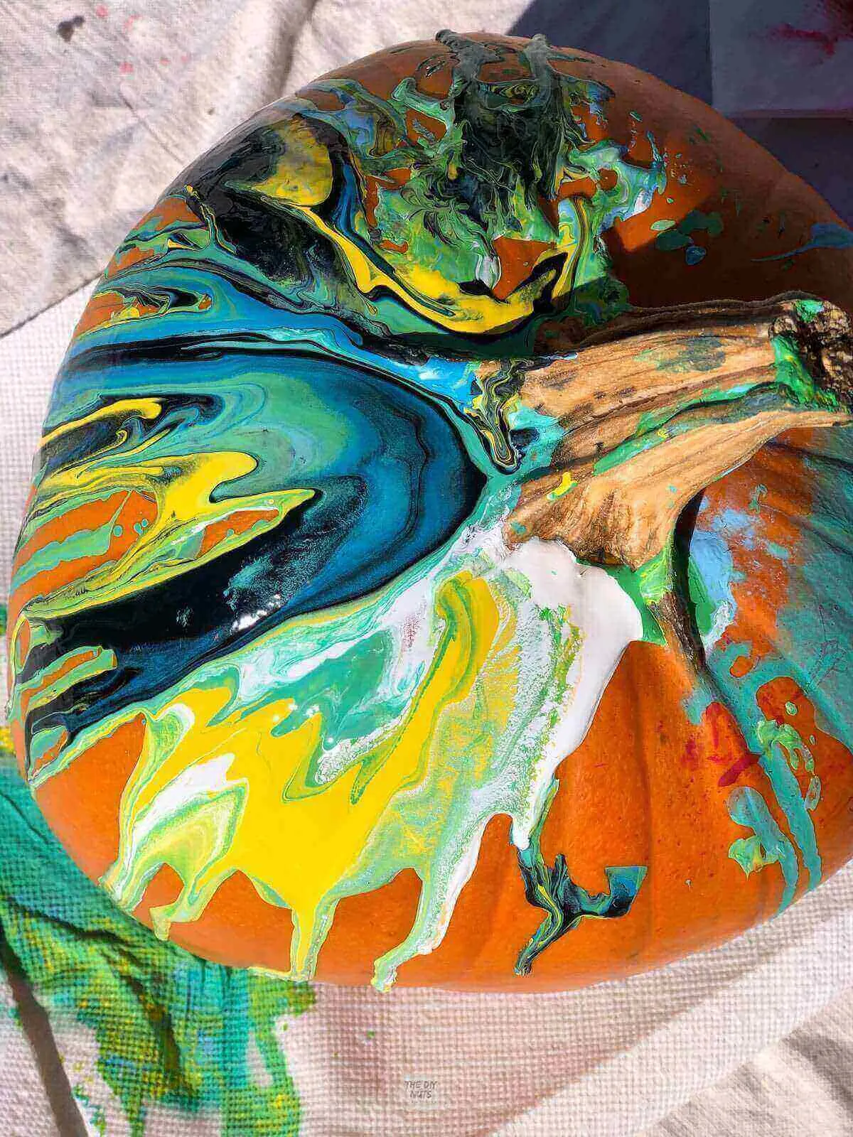 Top view of a pumpkin with paint pour technique used to decorate.