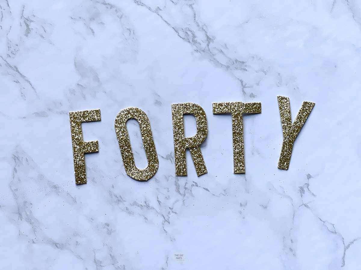 glitter letters spelling forty on marble table.