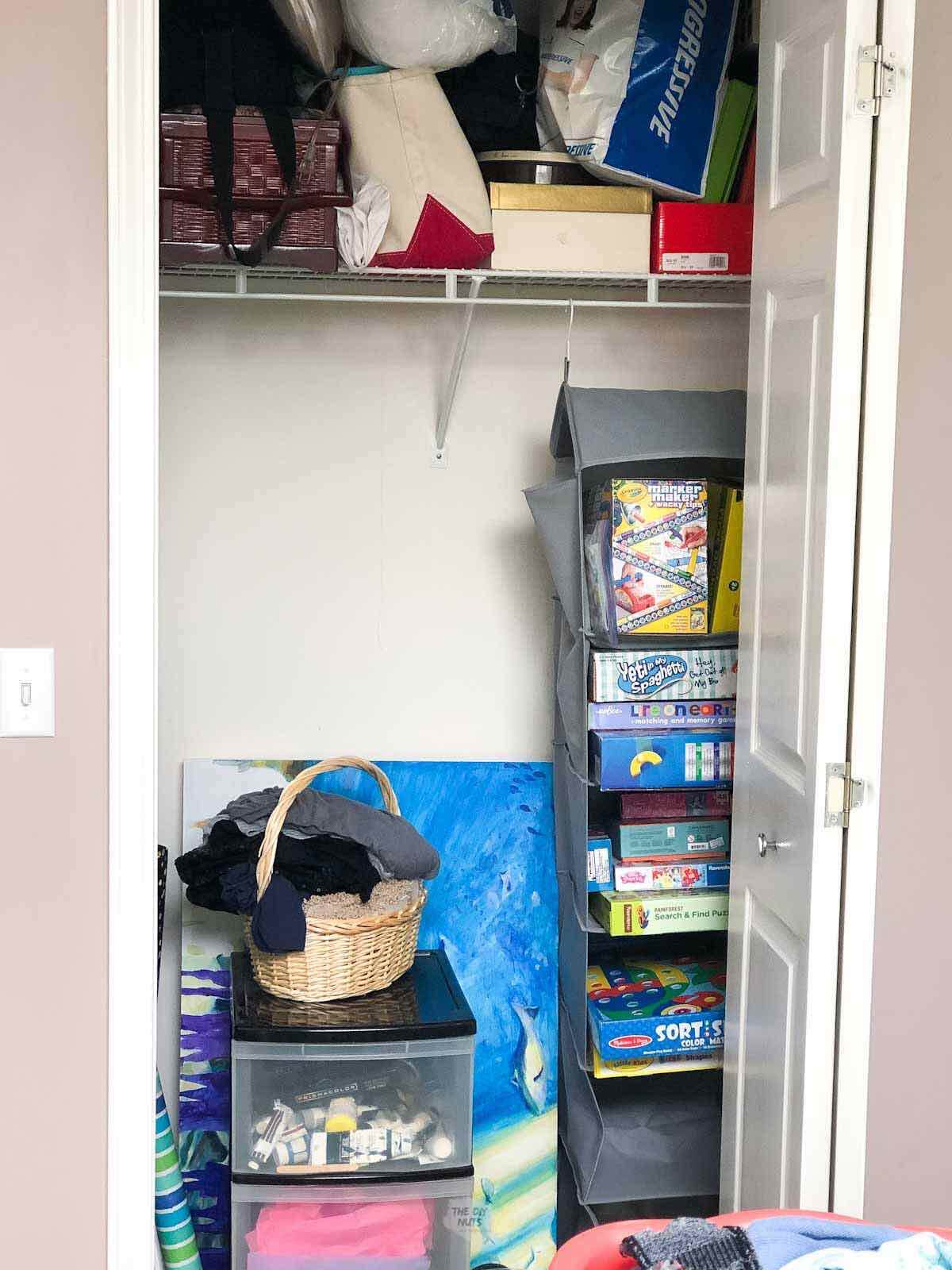 Unorganized small closet with wire shelving and variety of items piled on top of each other.