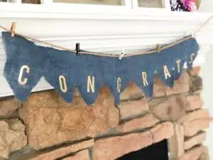 blue burlap banner with gold letters saying congrats.