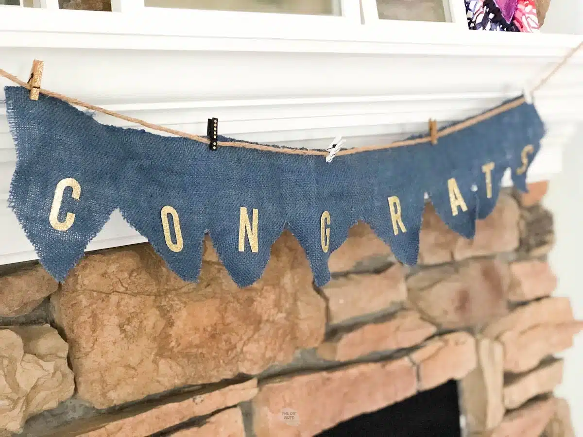 blue burlap banner saying congrats hanging on fireplace.
