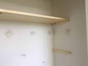Pine wood for DIY shelves resting on simple homemade shelf bracket in closet.