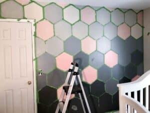 hexagon patterned wall with painter's tape and ladder.