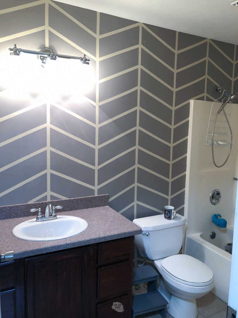How To Paint A DIY Herringbone Bathroom Accent Wall Pattern - The DIY Nuts