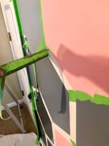 hand pulling painter's tape off of hexagon wall design.