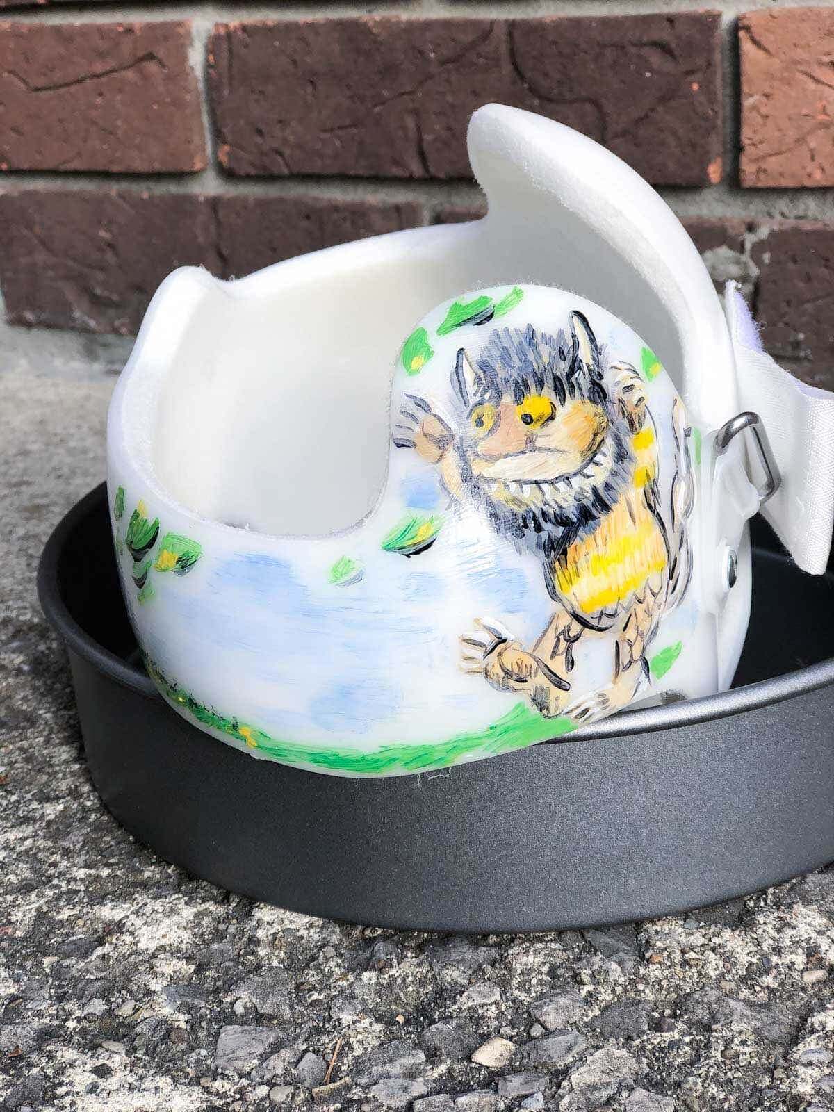 painted baby helmet in baking dish outside drying in the sun.