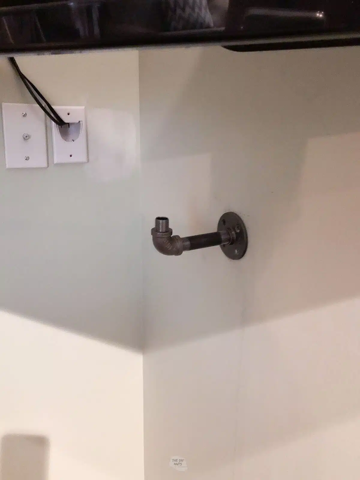 pipe fitting for shelf in wall corner under televsion.