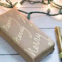 DIY wrapping paper wrapped on box in front of Christmas lights.