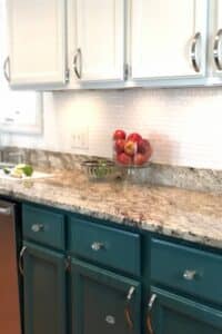 white and green painted kitchen cabinets with granite counters.