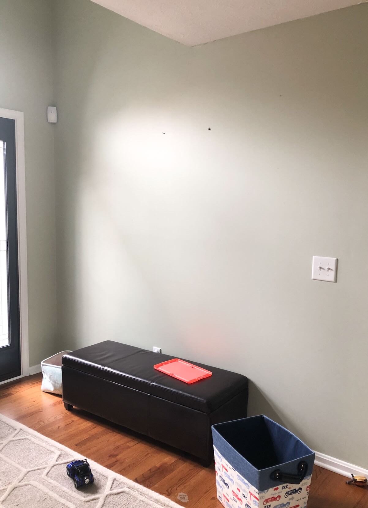 blank wall with toy chest and basket on floor.