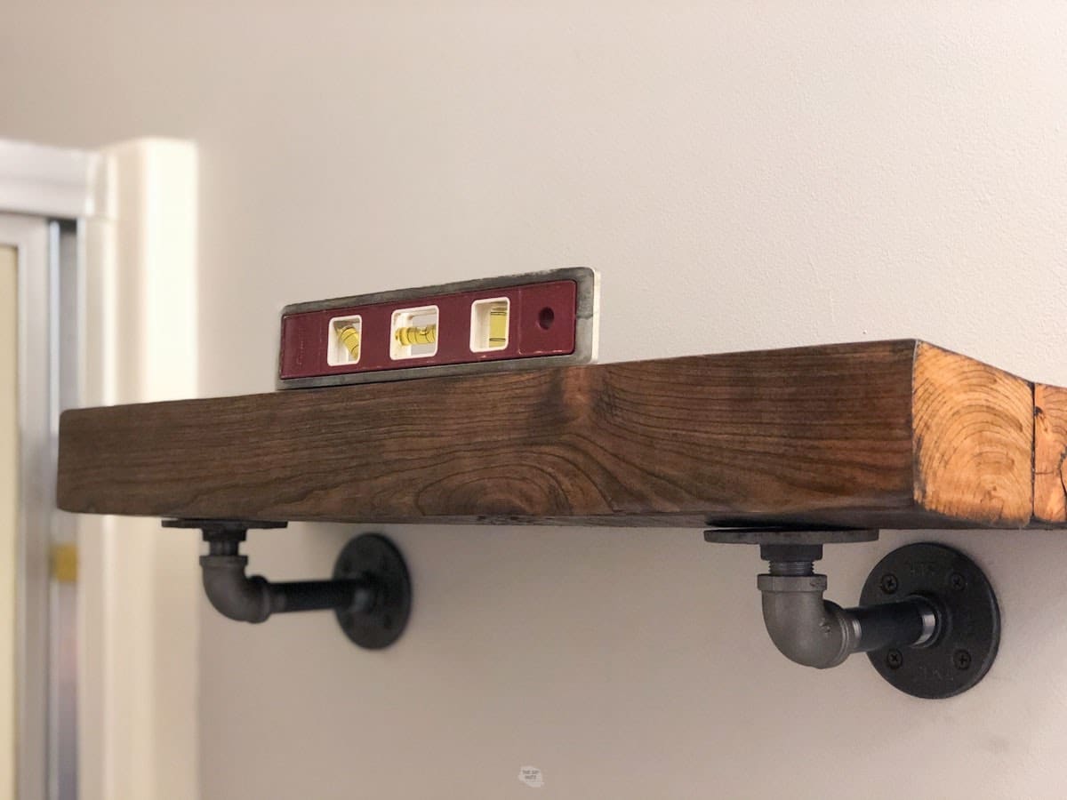 reclaimed wood shelf with small level on it.