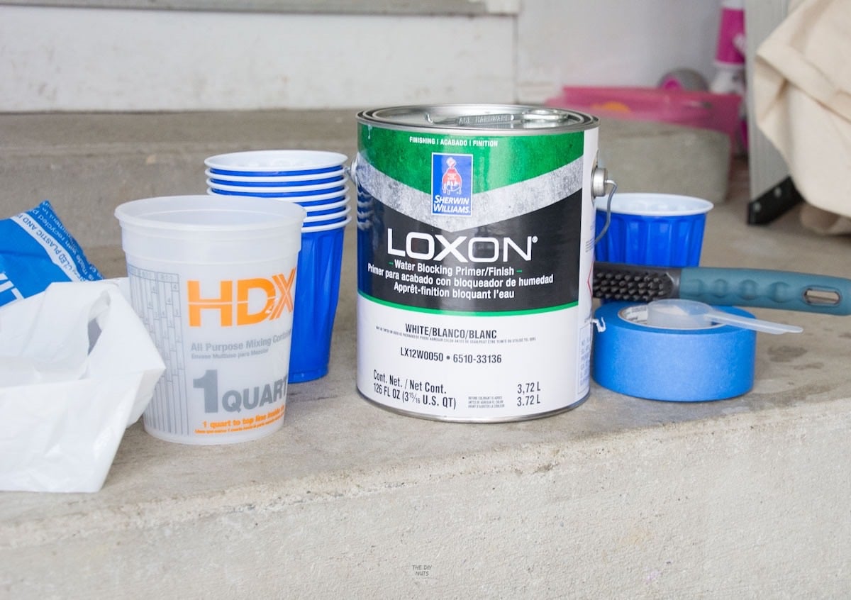 loxon paint, cups, painter's tape in garage.