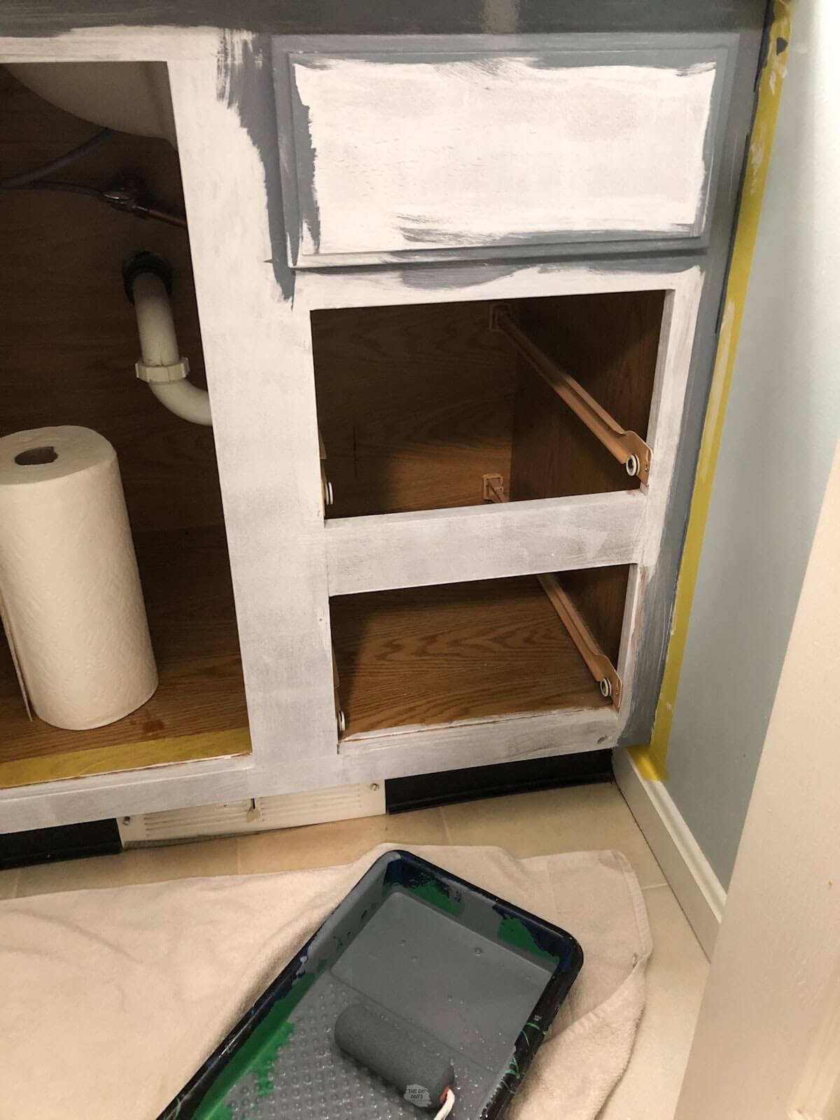 bathroom cabinet box with primer and new coat of gray paint being added.